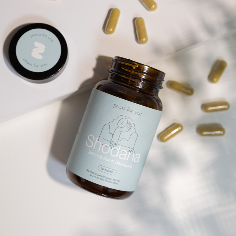 Shodana Nahrungsergänzung geöffnetes Glas und Kapseln